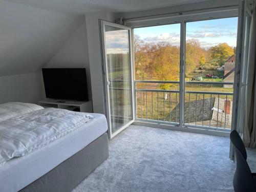 ein Schlafzimmer mit einem Bett und einem großen Fenster in der Unterkunft Apartment mit Weitblick 