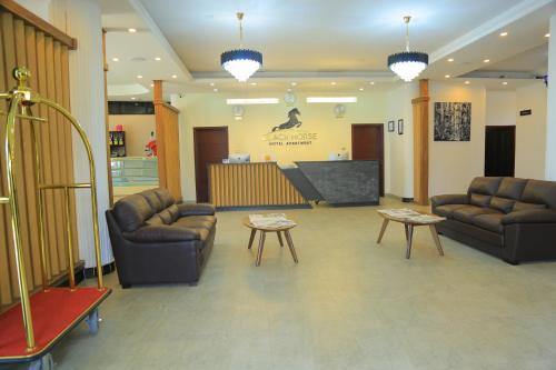 a living room with couches and a flat screen tv at Black Horse Hotel in Addis Ababa