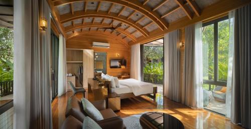 a bedroom with a bed and a living room at The Hidden Village, Khao Yai in Mu Si