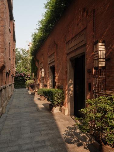 a brick alley with potted plants next to a building at Capella Shanghai, Jian Ye Li in Shanghai