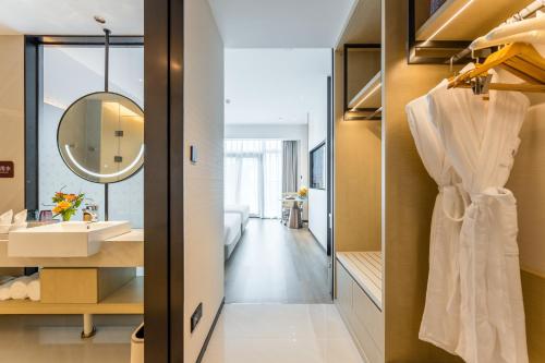 a bathroom with a sink and a mirror at Kew Green Hotel Mianshuicheng Haikou in Haikou