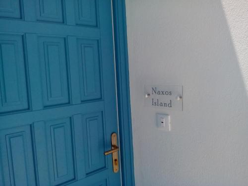 a blue door with a sign that reads nassos island at Cycladic Islands Hotel & Spa in Agia Anna Naxos