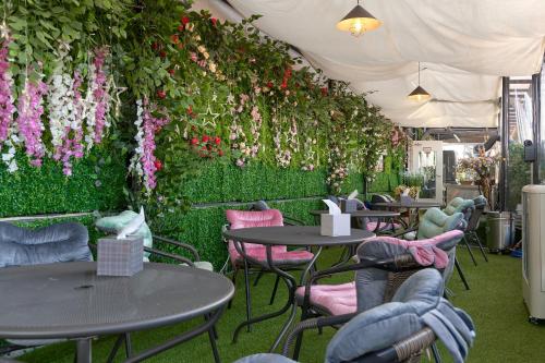 ein Restaurant mit Tischen und Stühlen mit Blumen an der Wand in der Unterkunft Snowflower Guesthouse in Seoul