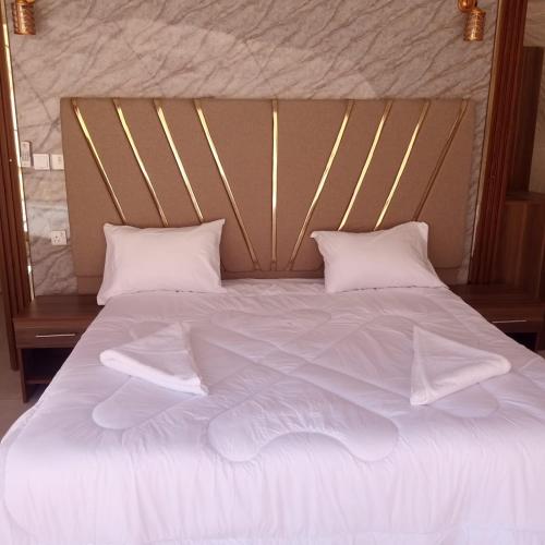 a large bed with white sheets and pillows at غرووب وادي رم in Wadi Rum