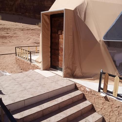 a tent with steps leading up to a door at غرووب وادي رم in Wadi Rum