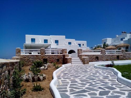a walkway in front of a white building at Cycladic Islands Hotel & Spa in Agia Anna Naxos