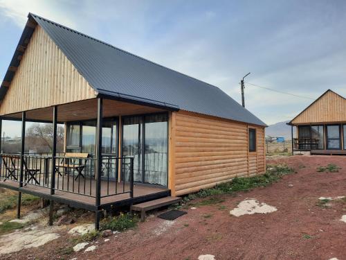 uma cabina de madeira com um telhado preto e janelas em Nirok em Sevan