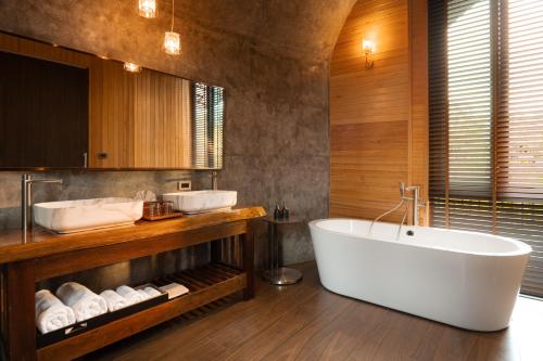 a bathroom with a large tub and two sinks at The Hidden Village, Khao Yai in Mu Si