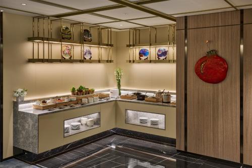 a restaurant with a counter with food on it at Grand HiLai Taipei in Taipei