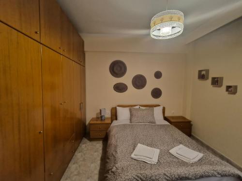 um quarto com uma cama e um relógio na parede em Vaso holidays em Alexandroúpolis
