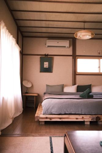a bedroom with a bed and a window in it at The Greenhouse in Myoko