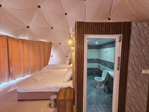 1 dormitorio con cama y bañera en una tienda en غرووب وادي رم en Wadi Rum