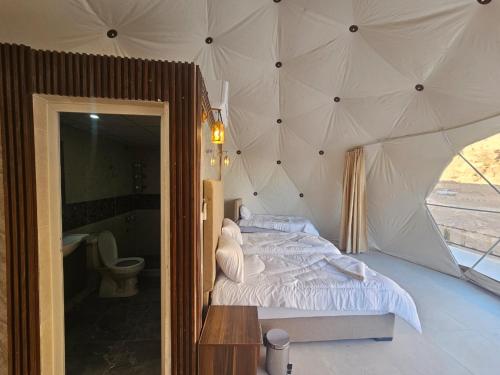 a bedroom with a bed in a tent at غرووب وادي رم in Wadi Rum