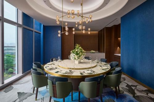 a dining room with a round table and chairs at Grand HiLai Taipei in Taipei