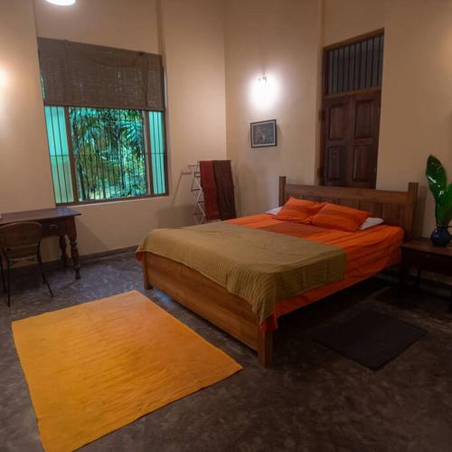 - une chambre avec un lit, un bureau et une fenêtre dans l'établissement Weralugama Forest House, 