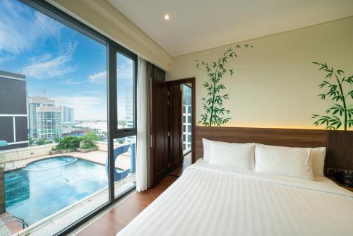 a bedroom with a bed and a large window at Northern Charm Hotel in Ho Chi Minh City
