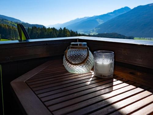 deux vases en verre assis sur une table sur un balcon dans l'établissement Holiday flat with National Park Card included, à Bramberg am Wildkogel