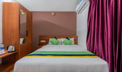 a bedroom with a bed with a red curtain at Treebo JP Residency in Trivandrum