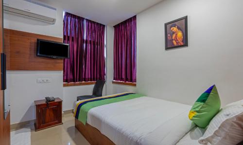 a hotel room with a bed and a tv at Treebo JP Residency in Trivandrum