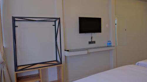 ein Schlafzimmer mit einem Spiegel und einem TV an der Wand in der Unterkunft ZerCity Otel in Konya