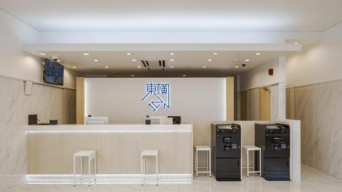 eine Lobby mit einer Theke und zwei Verkaufsautomaten in der Unterkunft Toyoko Inn Tenri Ekimae in Tenri