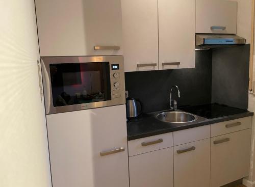 a small kitchen with a sink and a microwave at Ferienwohnung UP Willingen-Schwalefeld in Willingen