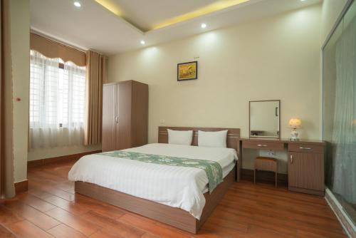 a bedroom with a bed and a desk with a mirror at Family Airport Hotel - 5 minutes Noi Bai in Noi Bai