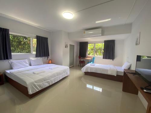Un dormitorio con dos camas y un televisor. en ศิวพฤกษ์ เพลส, en Nonthaburi