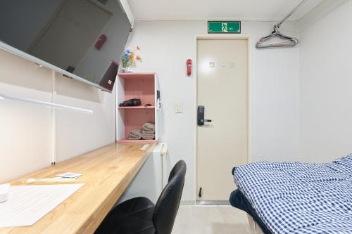 a small bedroom with a desk and a bed at Snowflower Guesthouse in Seoul