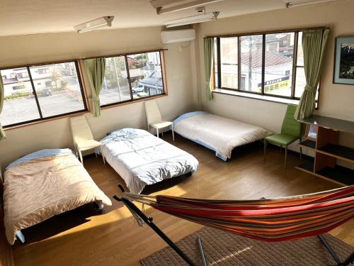 今市STAY - NIKKO private house rental only 5 min to station في نيكو: غرفة بسريرين وارجوحة فيها