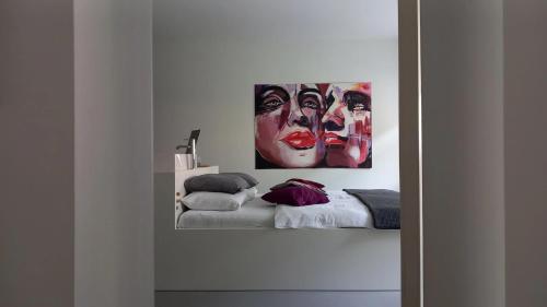 a bedroom with a bed and a painting of two women at Ferienwohnungen Mittermurnthal in Neunburg vorm Wald