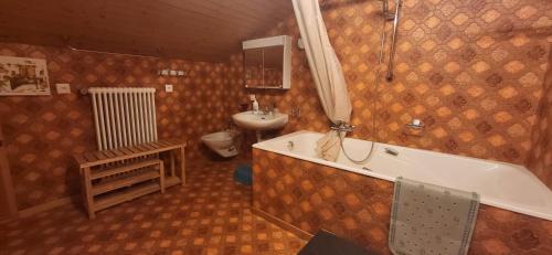 y baño con bañera, lavabo y aseo. en Fortuna en Bürchen