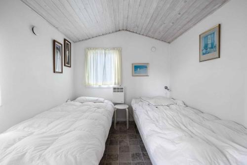 Charming Cottage In Mesinge في Mesinge: سريرين في غرفة بجدران بيضاء