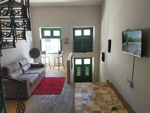 - un salon avec un canapé et deux portes vertes dans l'établissement Casa Prudente, à Olinda