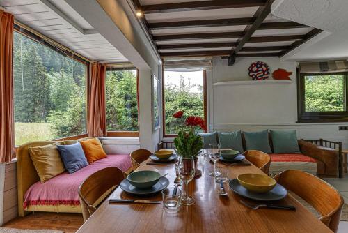 une salle à manger avec une table et un canapé dans l'établissement chalet l'ilet ensoleillé /Sunny Island Chalet, à Chamonix-Mont-Blanc