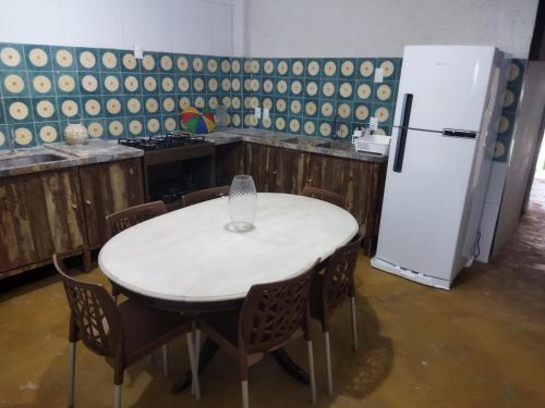 a kitchen with a white table and a refrigerator at Casa Prudente in Olinda