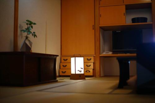 a light in a room with a desk and a tv at 海のほてる　いさば in Numazu