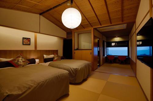 a hotel room with two beds and a television at 海のほてる　いさば in Numazu