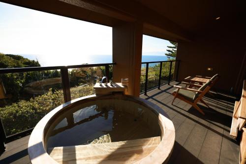 a bath tub on a balcony with a view of the ocean at 海のほてる　いさば in Numazu