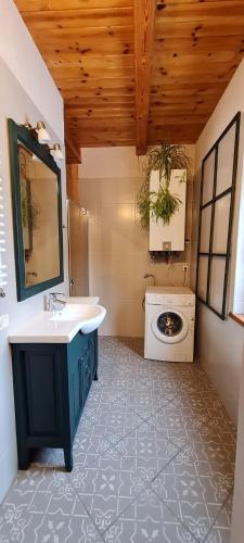a bathroom with a sink and a washing machine at Klimatyczny drewniany dom z kominkiem nad jeziorem Mielno w 2h z Warszawy i Gdanska in Olsztynek