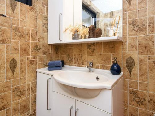 W łazience znajduje się umywalka i lustro. w obiekcie Holiday home Aabenraa LXXVII w mieście Aabenraa
