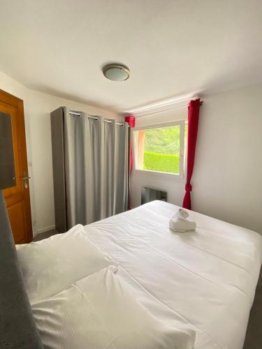 een slaapkamer met een groot wit bed en een raam bij "Là-haut" free parking in Trois-Épis