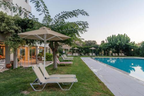 a pair of lounge chairs and an umbrella next to a pool at Luxury Villa Muse Calliope in Matala