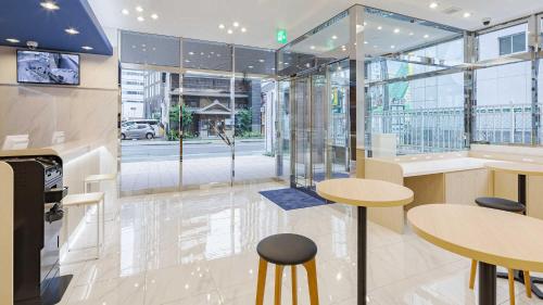 un restaurante con 2 mesas y paredes de cristal en Toyoko Inn Nagoya-eki Sakuradori-guchi Shinkan en Nagoya