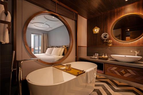 La salle de bains est pourvue d'une baignoire, d'un lavabo et d'un miroir. dans l'établissement Fusion Original Saigon Centre, à Hô-Chi-Minh-Ville