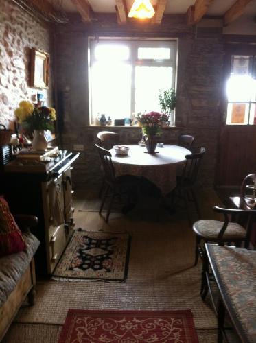 a living room with a table and a window at Five Saints Farmhouse B&B in Pumpsaint
