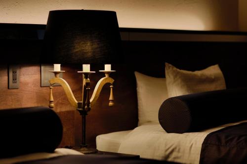 a bedroom with a bed and a lamp next to a bed sidx sidx at 海のほてる　いさば in Numazu