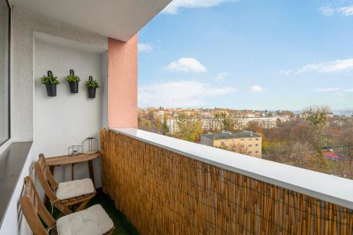 a balcony with two chairs and a view of a city at Gdynia z widokiem na morze by Downtown Apartments in Gdynia