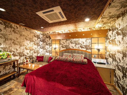 ein Schlafzimmer mit einem großen roten Bett und einem Sofa in der Unterkunft Rose Lips Shinsaibashi ローズリップス心斎橋 in Osaka