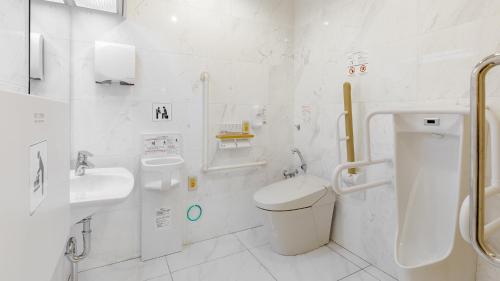 Baño blanco con aseo y lavamanos en Toyoko Inn Tokuyama-eki Kita-guchi, en Shunan